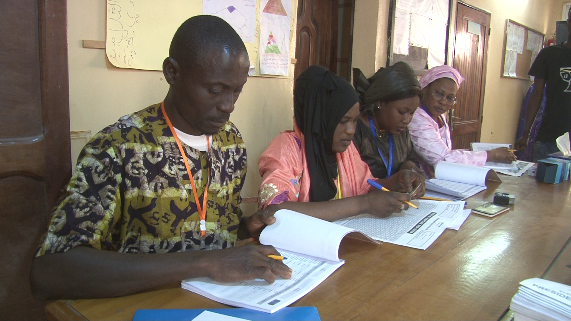 ممثلو بعض المتنافسين في الانتخابات السنغالية أثناء التأكد من وجود اسم أحد الناخبين على اللائحة.