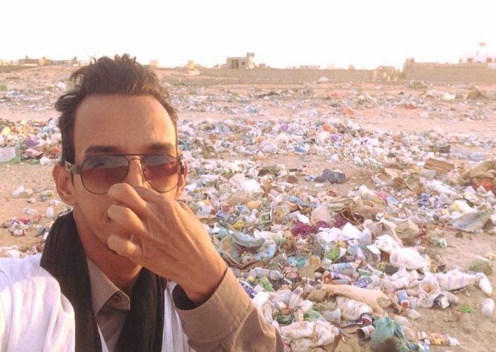 أحد النشطاء نشر صورته وهو يمسك أنفسه قرب تجمع للقمامة في أحد أحياء نواكشوط