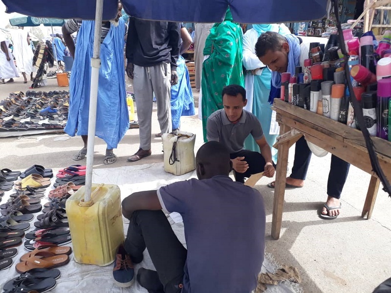 أحد طلاب كلية الطب يشرح لأحد الباعة في محيط السوق المركزي أهمية التبرع بالدم